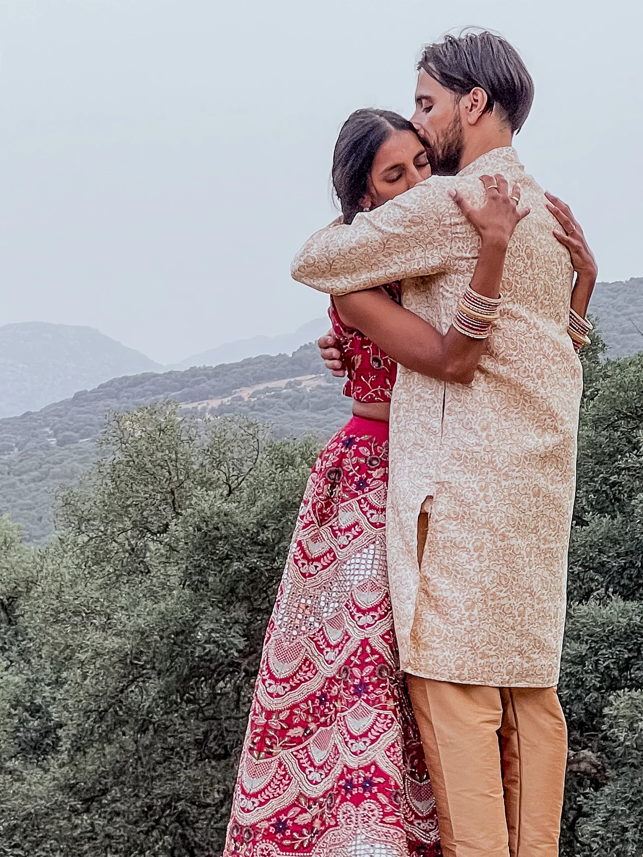 Joy y Opi abrazados el día de su boda, con las montañas de Grazalema al fondo